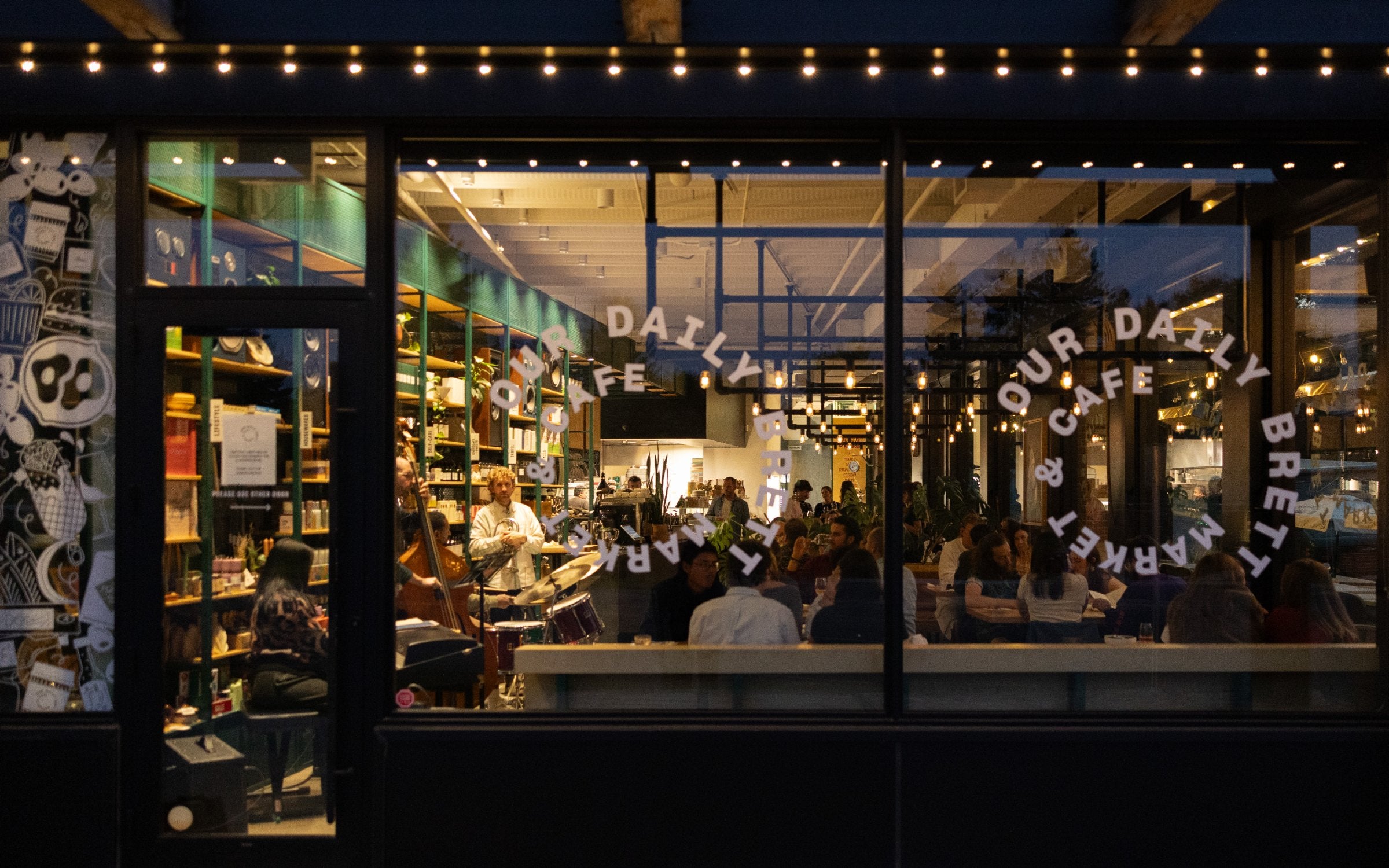 Our Daily Brett Market & Cafe at night, guests dining inside